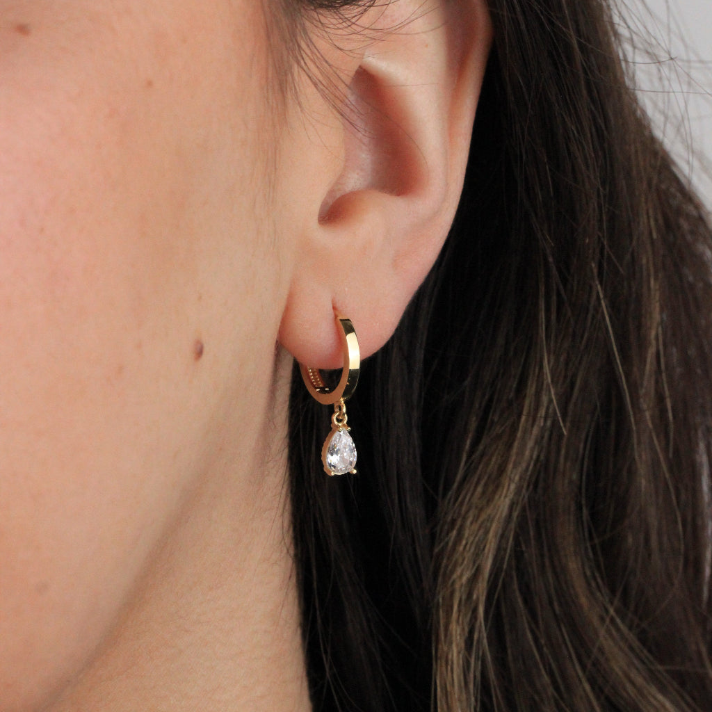 Pendientes de aro en oro amarillo de 18 quilates liso con forma aplanada y un colgante de circonita en forma de lágrima.
