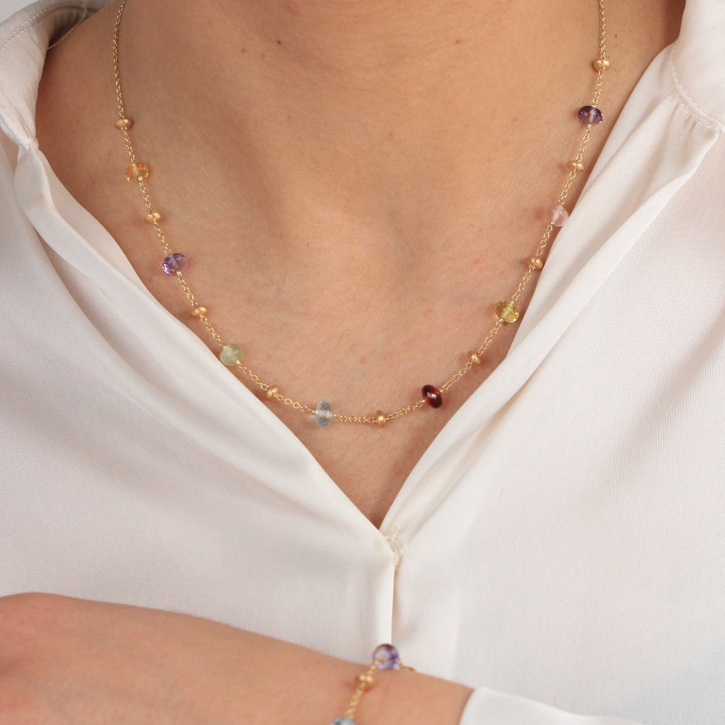 Gargantilla en oro amarillo de 18 quilates con piedras naturales en varios colores y motivos de oro matizados.