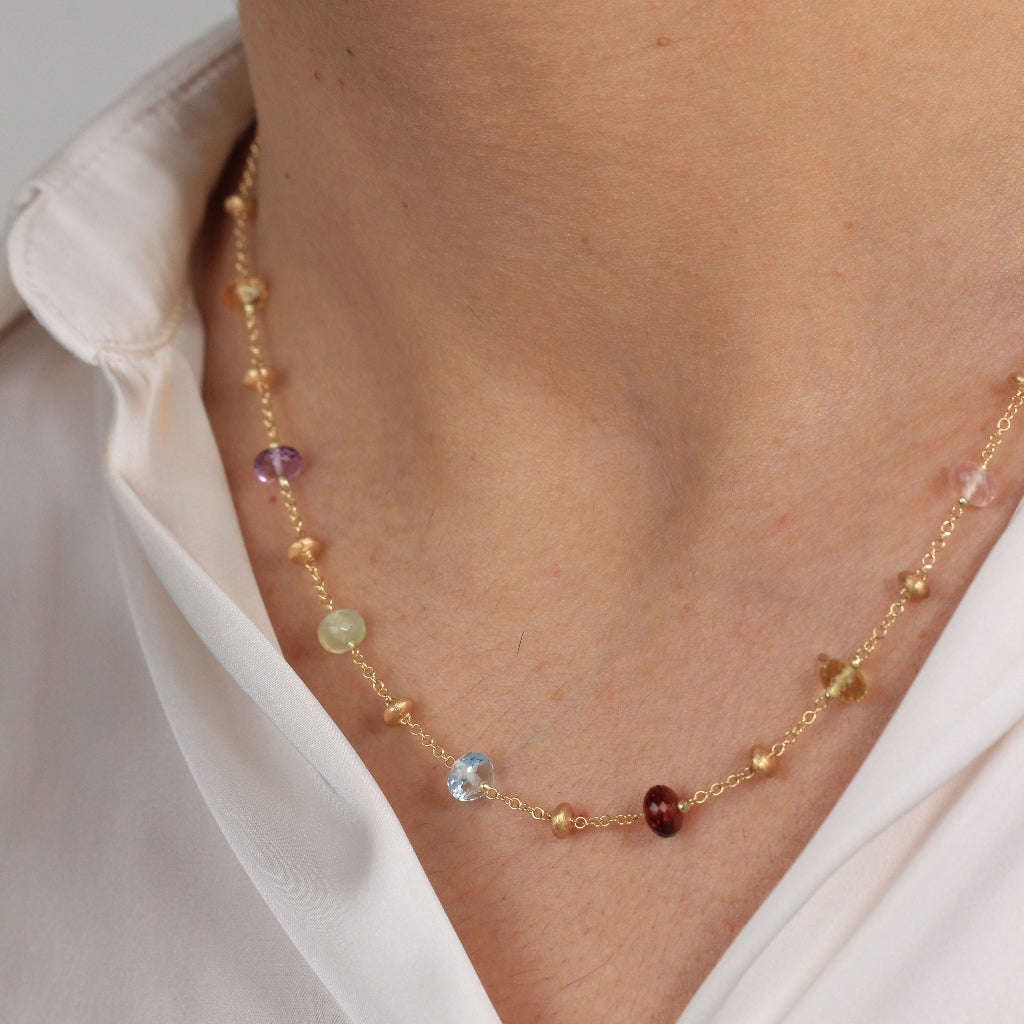 Gargantilla en oro amarillo de 18 quilates con piedras naturales en varios colores y motivos de oro matizados.