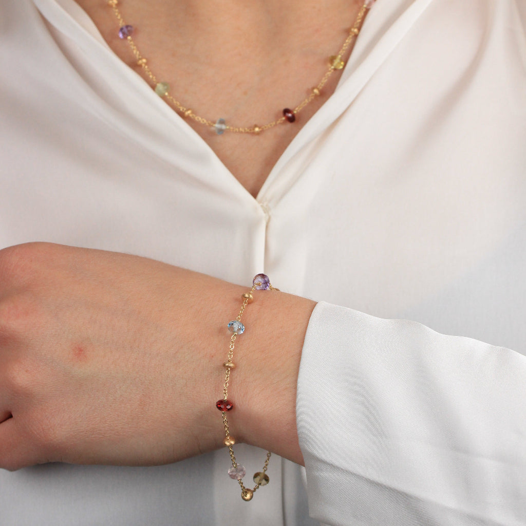 Pulsera realizada en oro amarillo de 18 quilates con motivos de oro y piedra natural de varios colores.