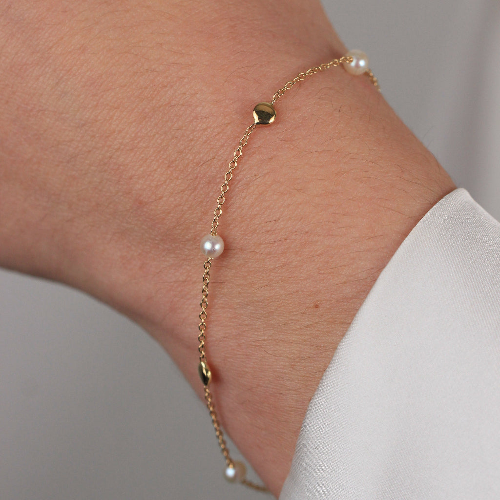 Pulsera realizada en oro amarillo de 18 quilates con motivos circulares lisos y perlas cultivadas