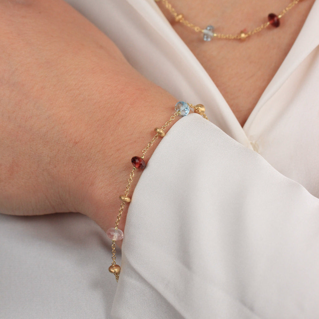 Pulsera realizada en oro amarillo de 18 quilates con motivos de oro y piedra natural de varios colores.