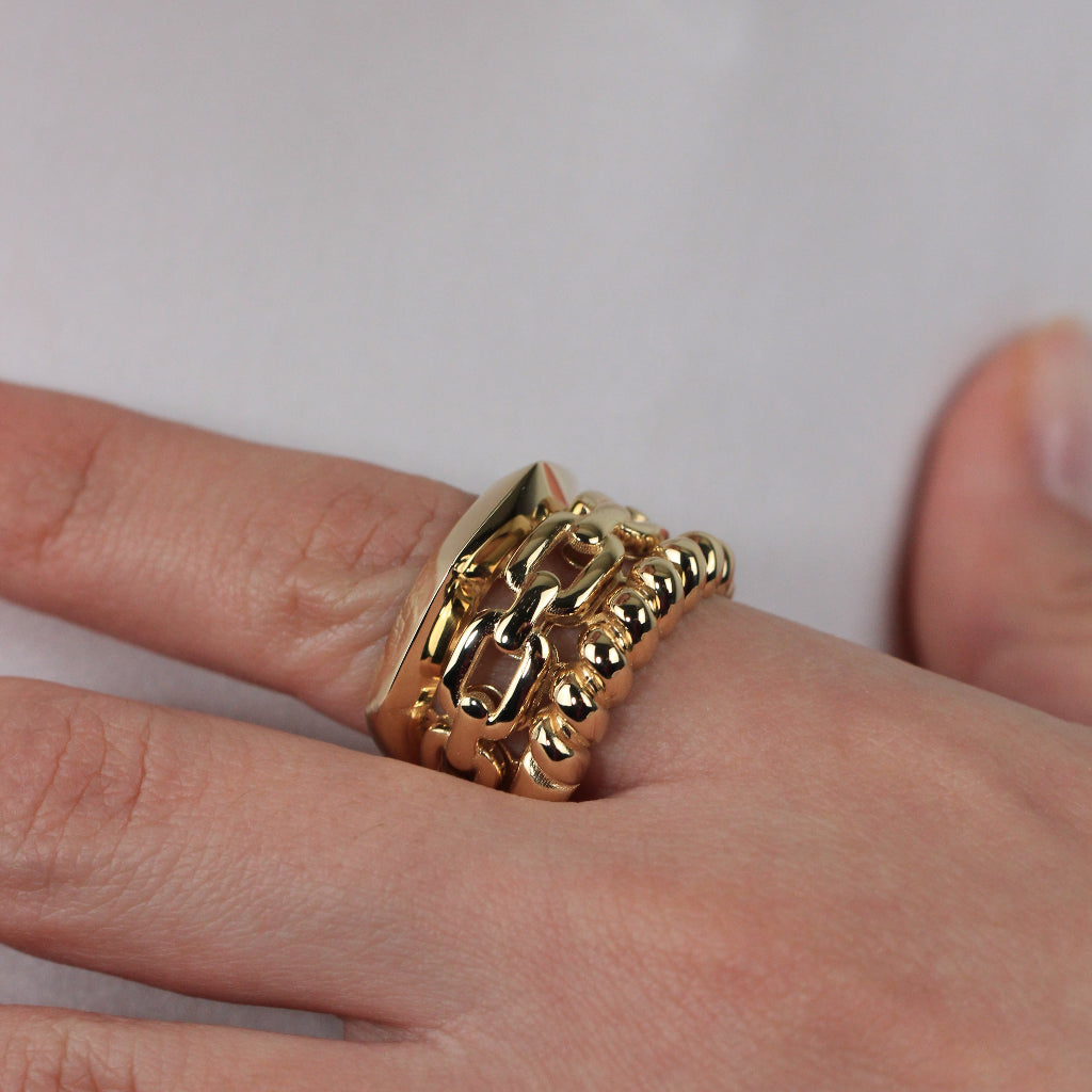 Anillo realizado en oro amarillo de 18 quilates con tres brazos con diferentes estilos.