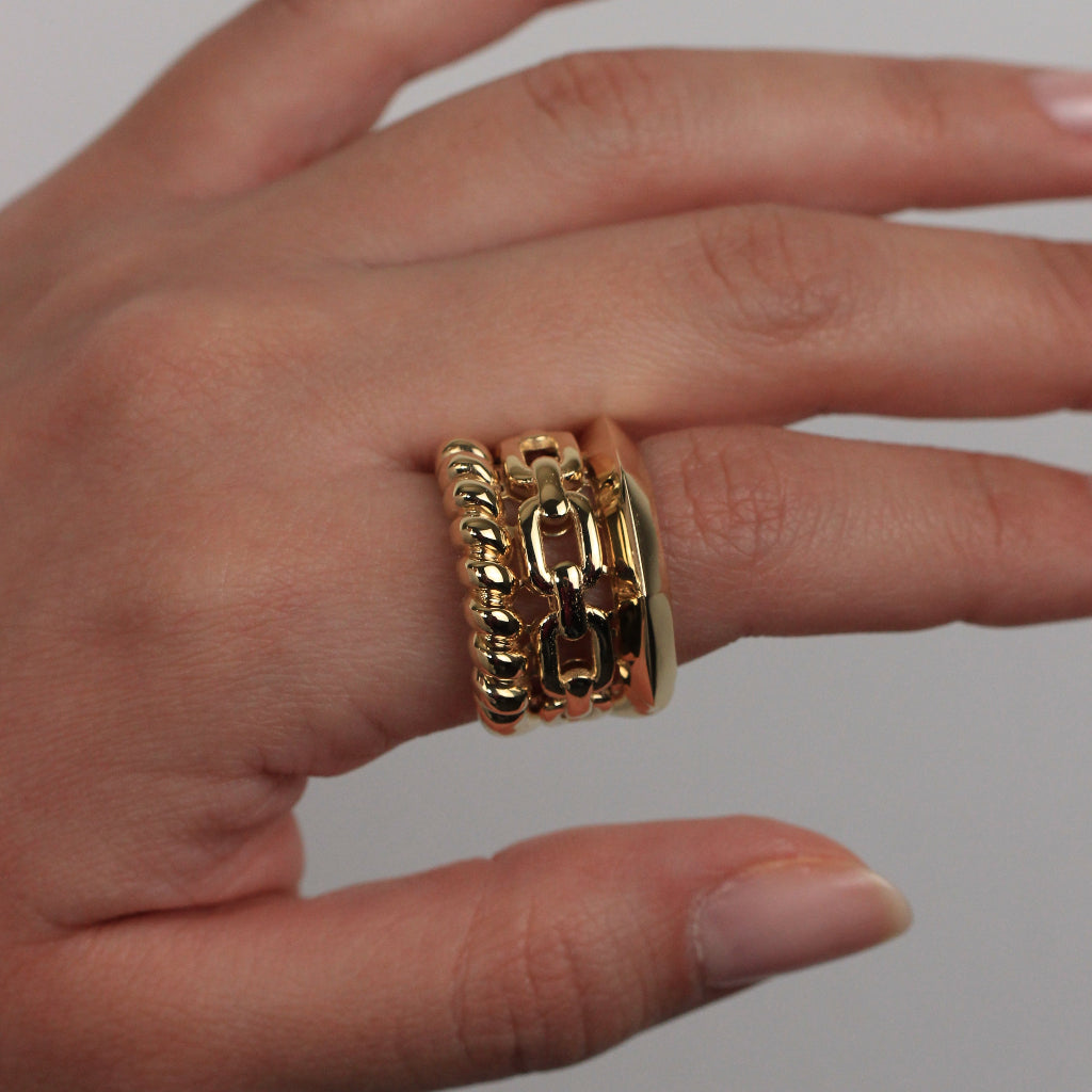 Anillo realizado en oro amarillo de 18 quilates con tres brazos con diferentes estilos.