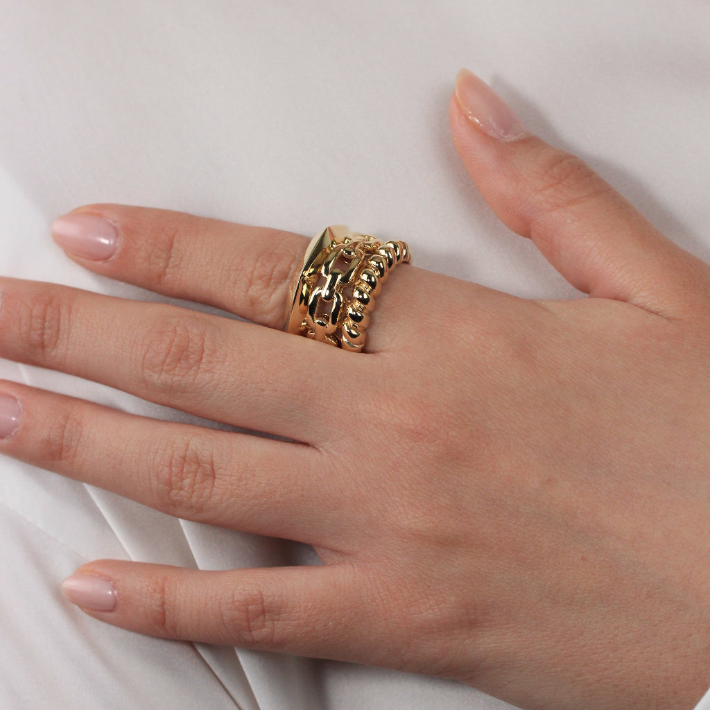 Anillo realizado en oro amarillo de 18 quilates con tres brazos con diferentes estilos.