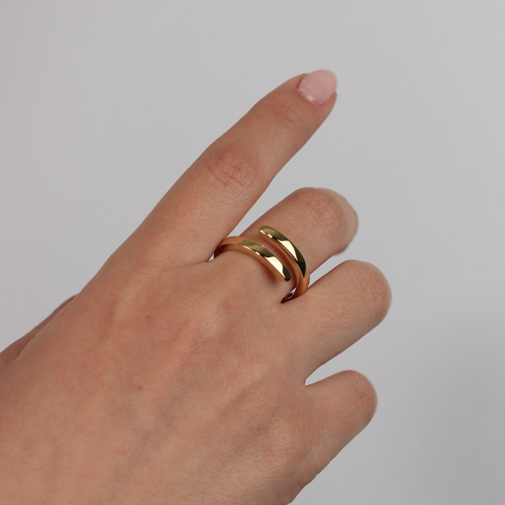 Sortija realizada en oro amarillo de 18 quilates con dos brazos.