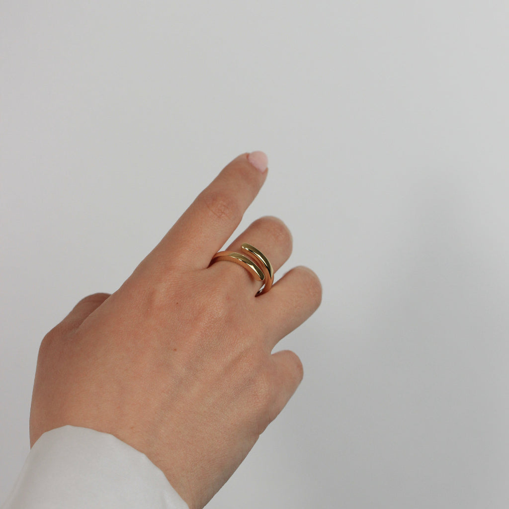 Sortija realizada en oro amarillo de 18 quilates con dos brazos.