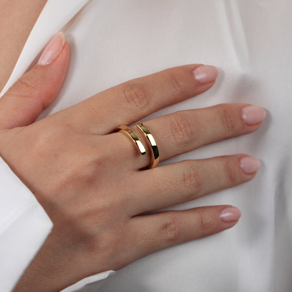 Sortija realizada en oro amarillo de 18 quilates con dos brazos.