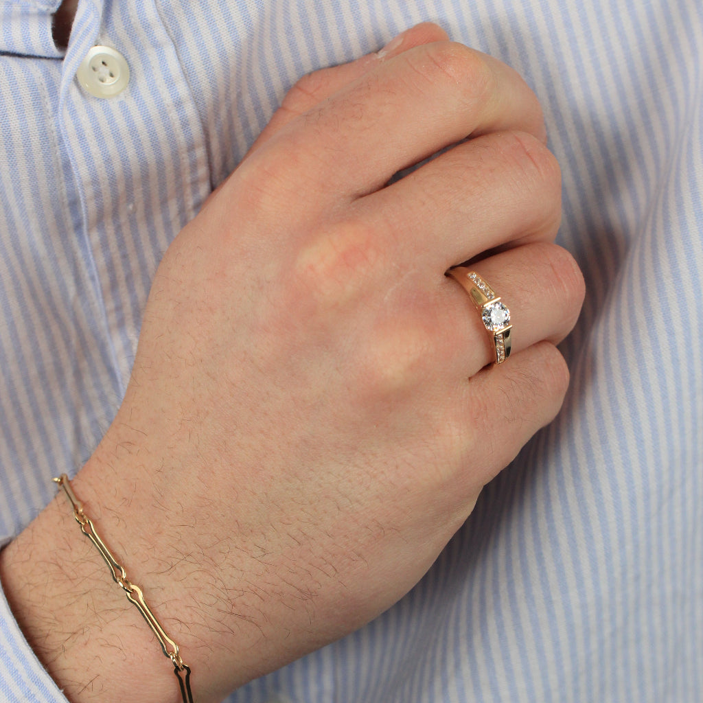 Sortija realizada en oro amarillo de 18 quilates con una circonita y circonitas en los brazos.