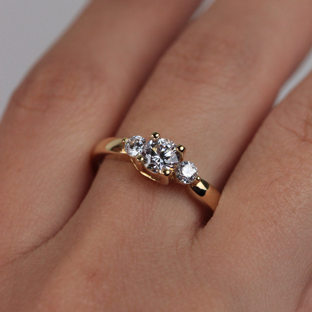 Sortija realizada en oro amarillo de 18 quilates con tres circonitas incoloras.