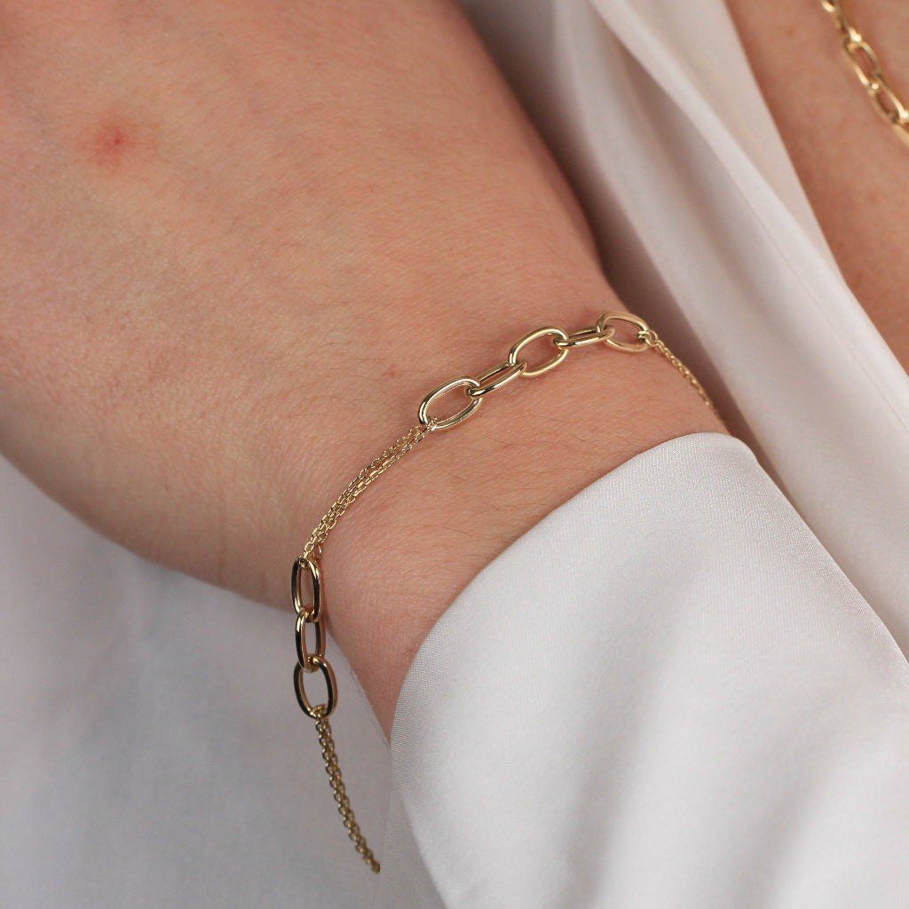 Pulsera realizada en oro amarillo de 18 quilates con eslabones intercalados con dos cadenas.