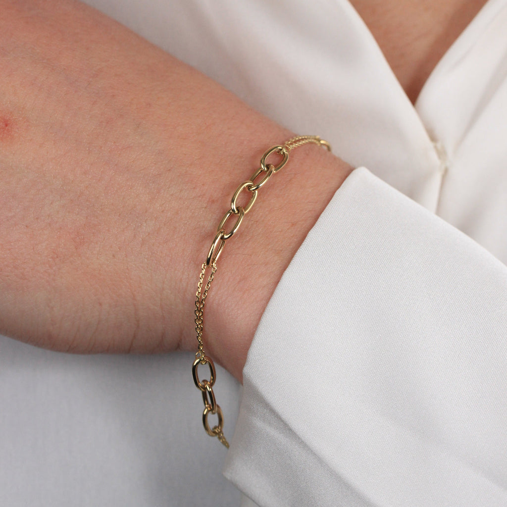 Pulsera realizada en oro amarillo de 18 quilates con eslabones intercalados con dos cadenas.