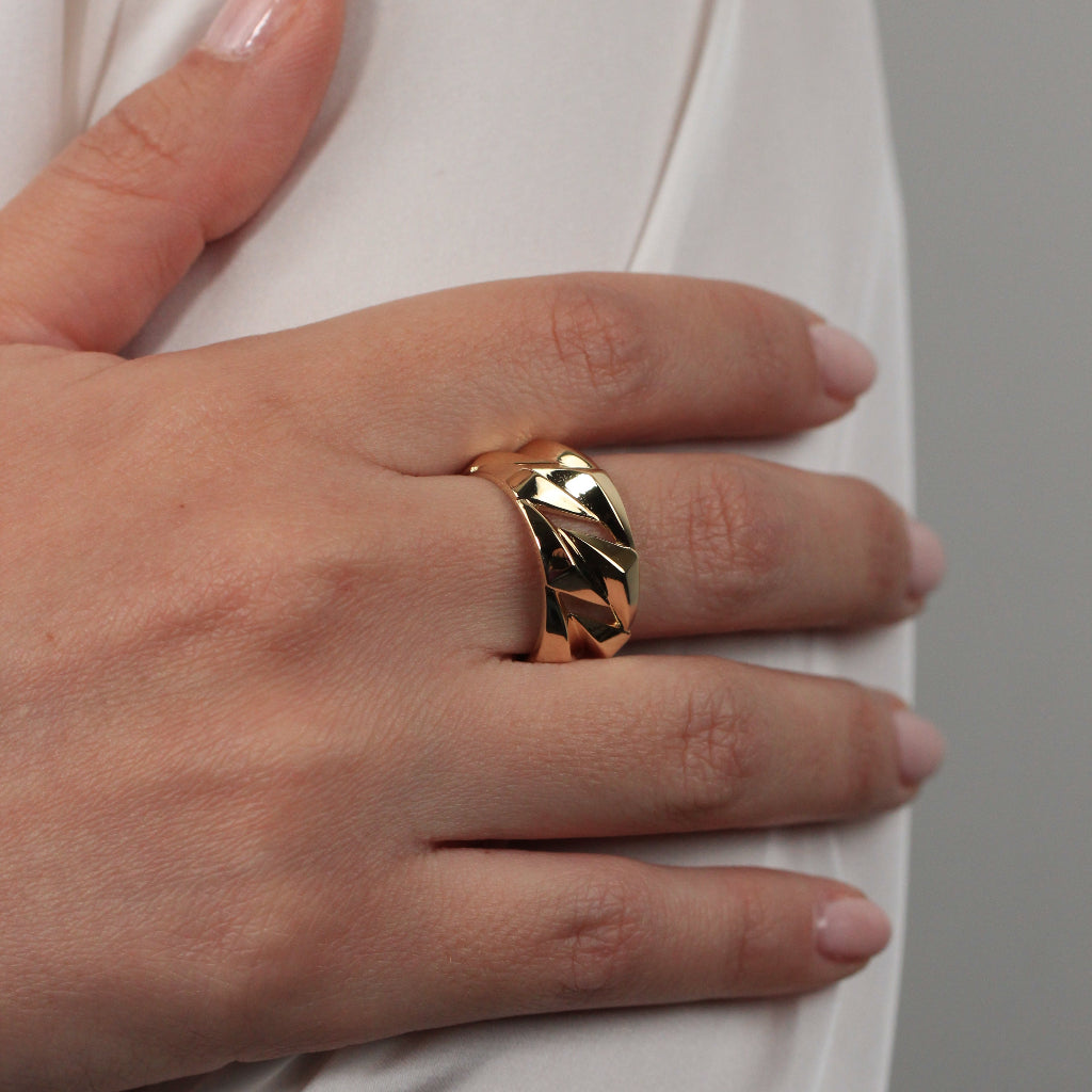 Sortija realizad en oro amarillo de 18 quilates con un diseño poligonal en relieve con huecos. El ancho del anillo es de 10mm.