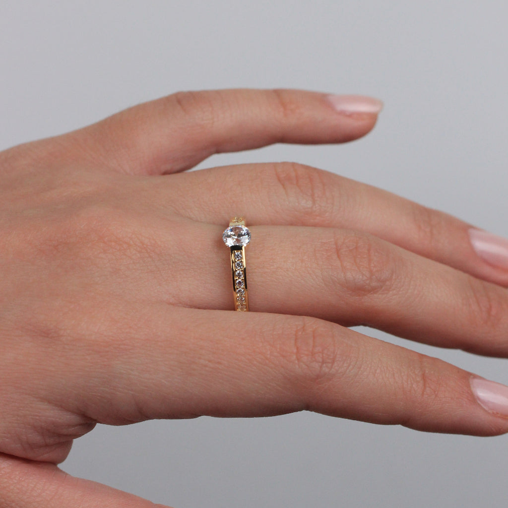 Sortija realizada en oro amarillo de 18 quilates con un solitario de circonita y circonitas en los brazos.