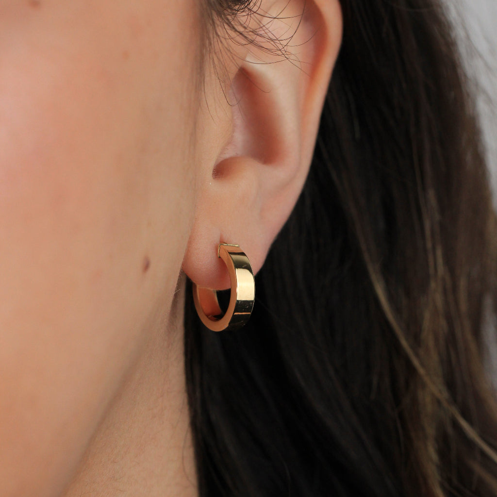 Pendientes de aro en oro amarillo de 18 quilates liso con forma aplanada.