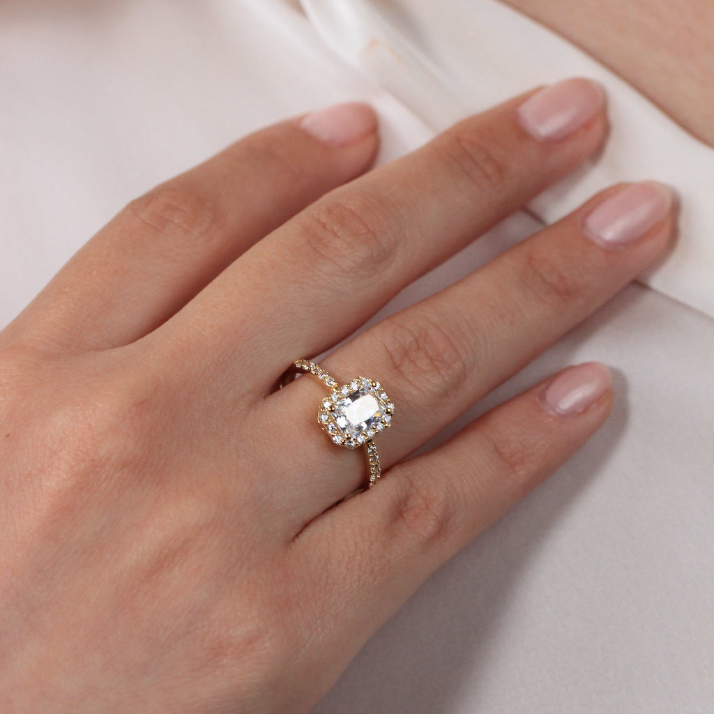 Sortija realizada en oro amarillo de 18 quilates con una circonita central, orla de circonitas y circonitas en los brazos