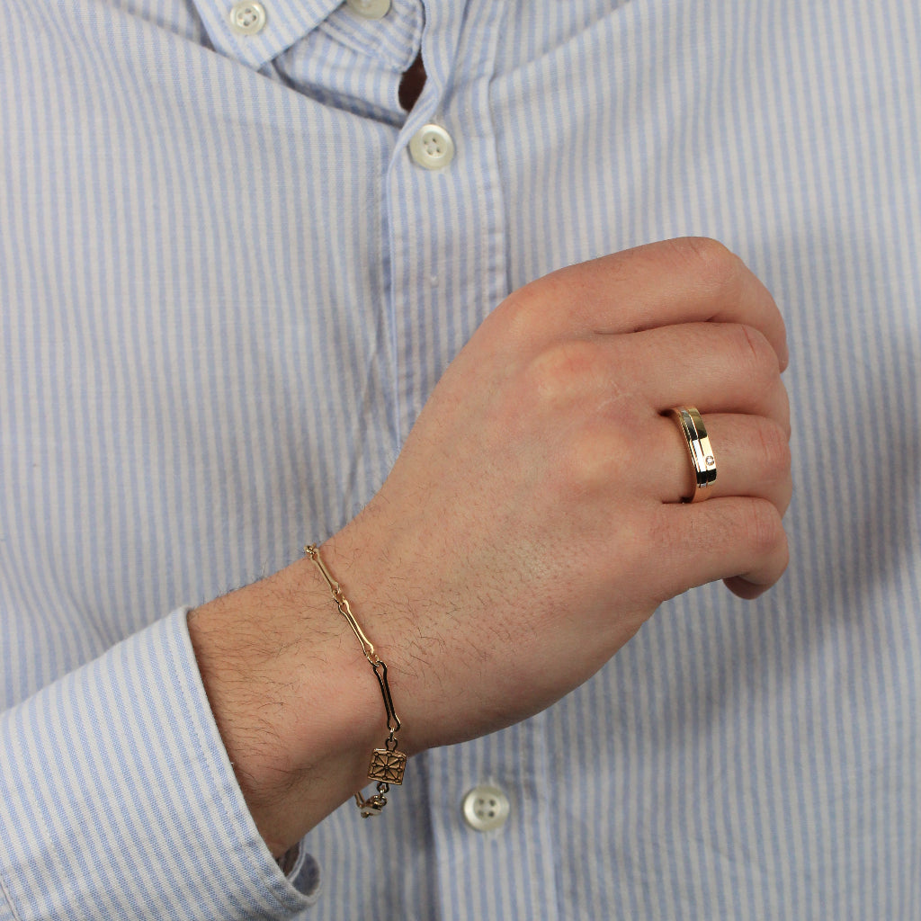 Sortija bicolor realizada en oro amarillo y blanco de 18 quilates con una banda central y una circonita engastada. El anillo tiene un ancho de 5,2mm.