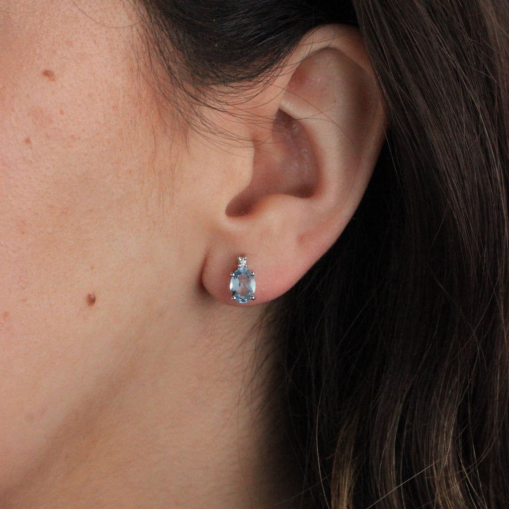 Pendientes tu y yo de oro blanco de 18 quilates con un topacio azul talla oval en garras y una circonita.