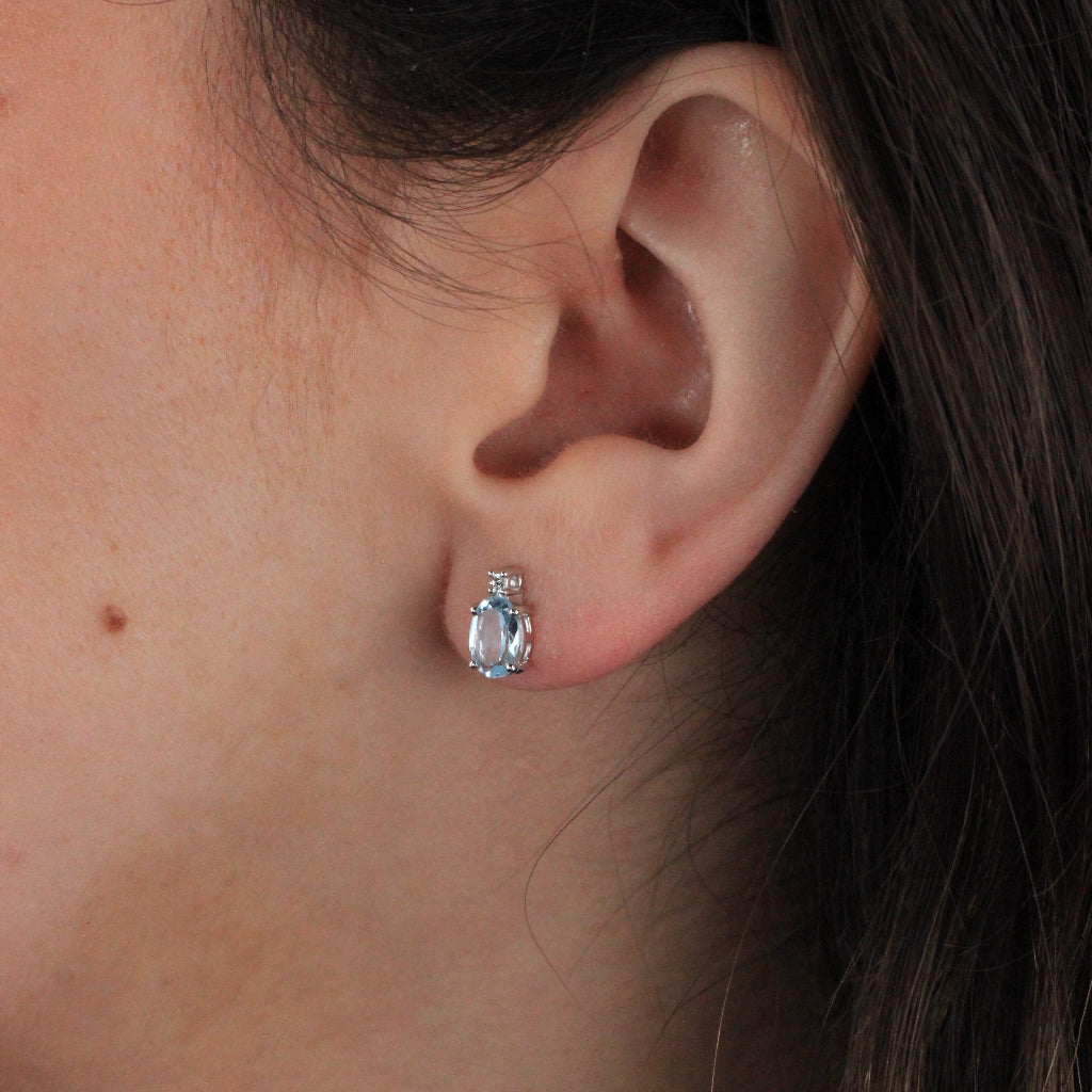 Pendientes tu y yo de oro blanco de 18 quilates con un topacio azul talla oval en garras y una circonita.