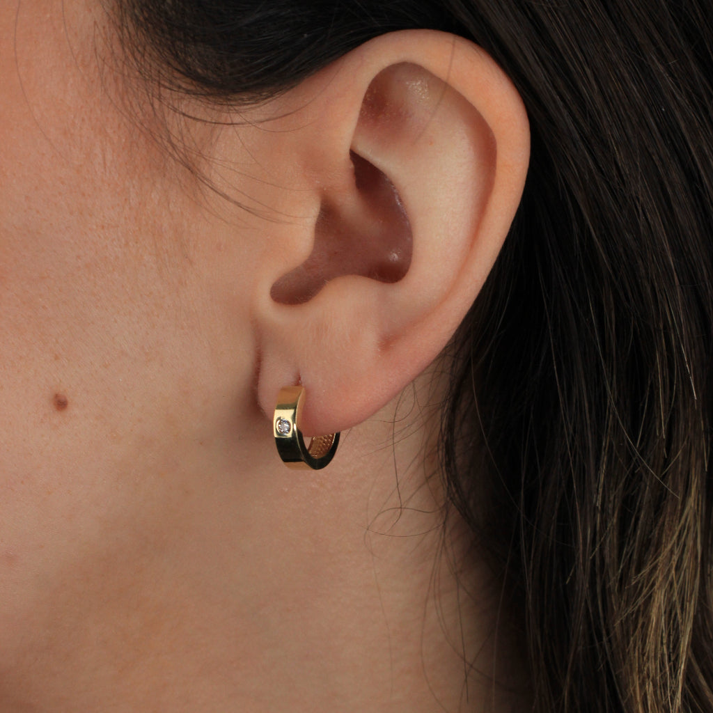 Pendientes de aro en oro amarillo de 18 quilates liso con forma aplanada y una circonita.