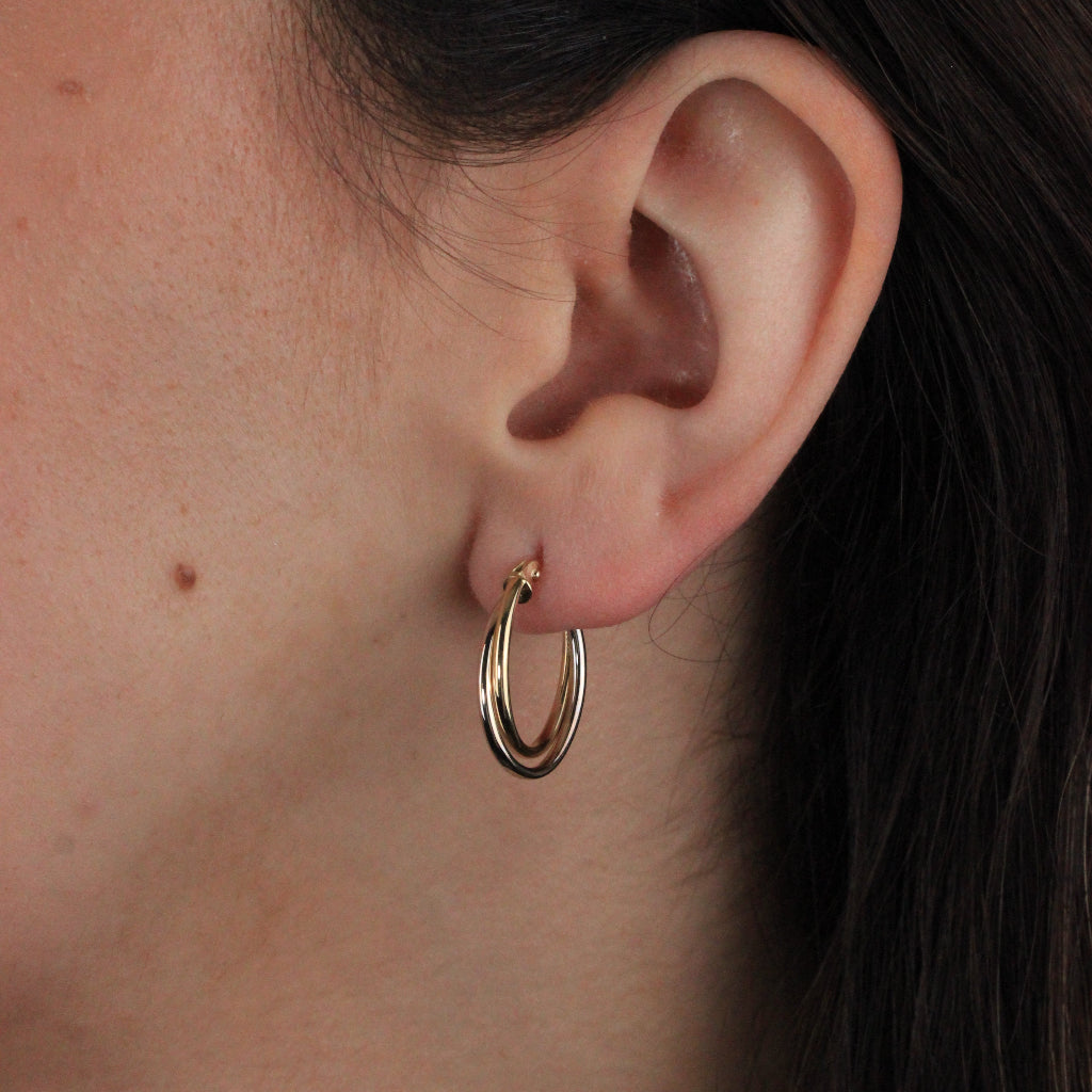 Pendientes de aro en oro blanco y amarillo de 18 quilates. El aro es doble con forma ovalada.