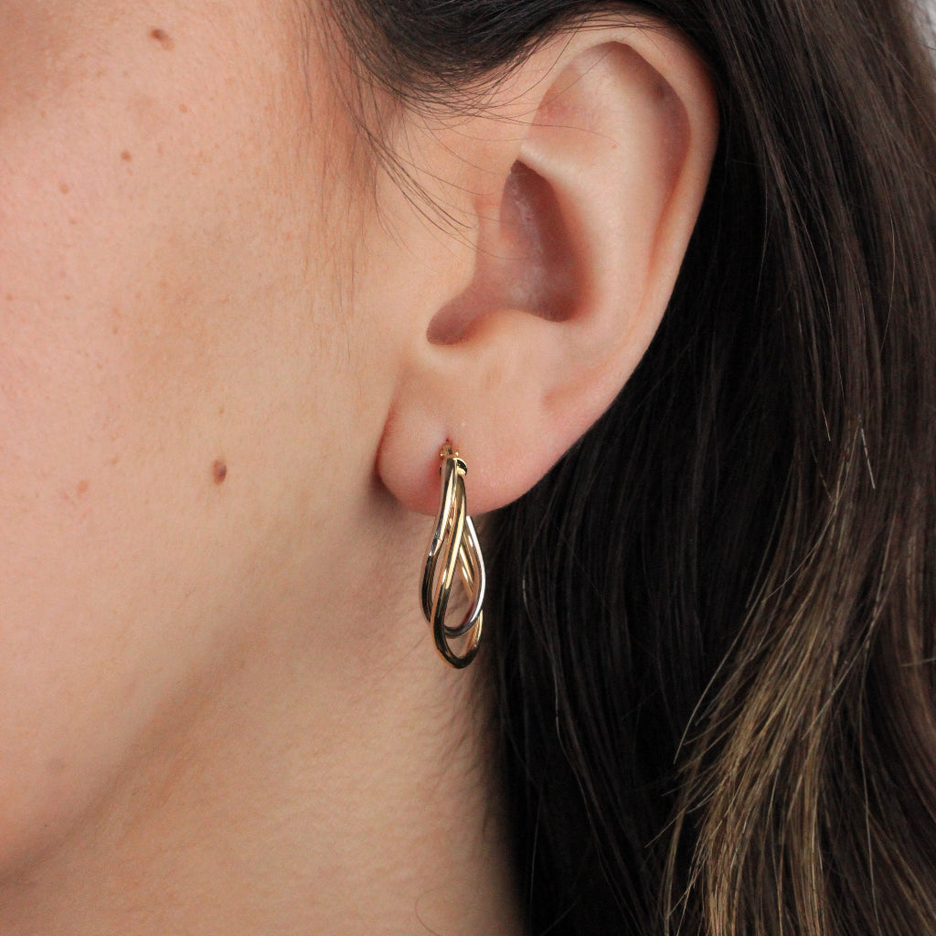 Pendientes de aro en oro blanco y amarillo de 18 quilates. El aro es doble con forma ovalada irregular.