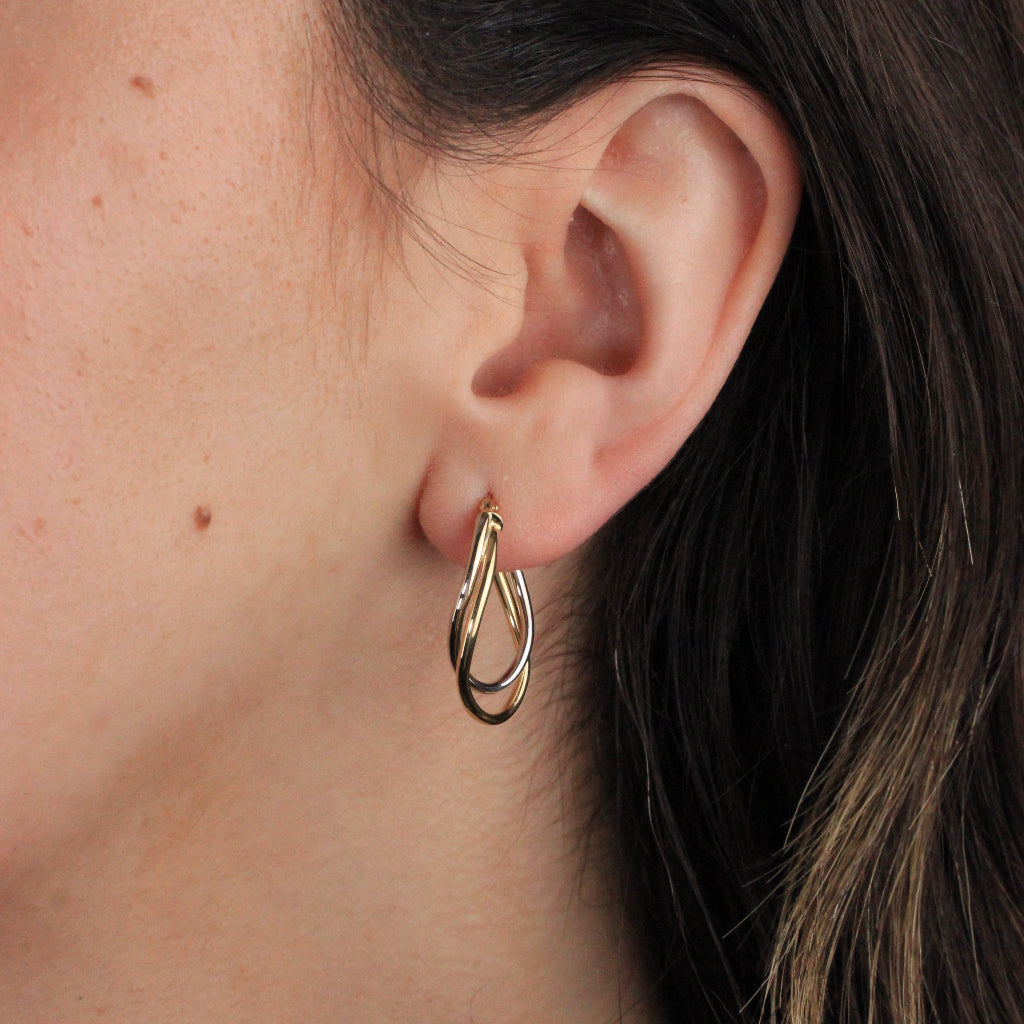 Pendientes de aro en oro blanco y amarillo de 18 quilates. El aro es doble con forma ovalada irregular.