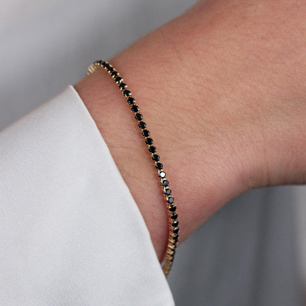 Pulsera realizada en oro amarillo de 18 quilates con circonitas negras.