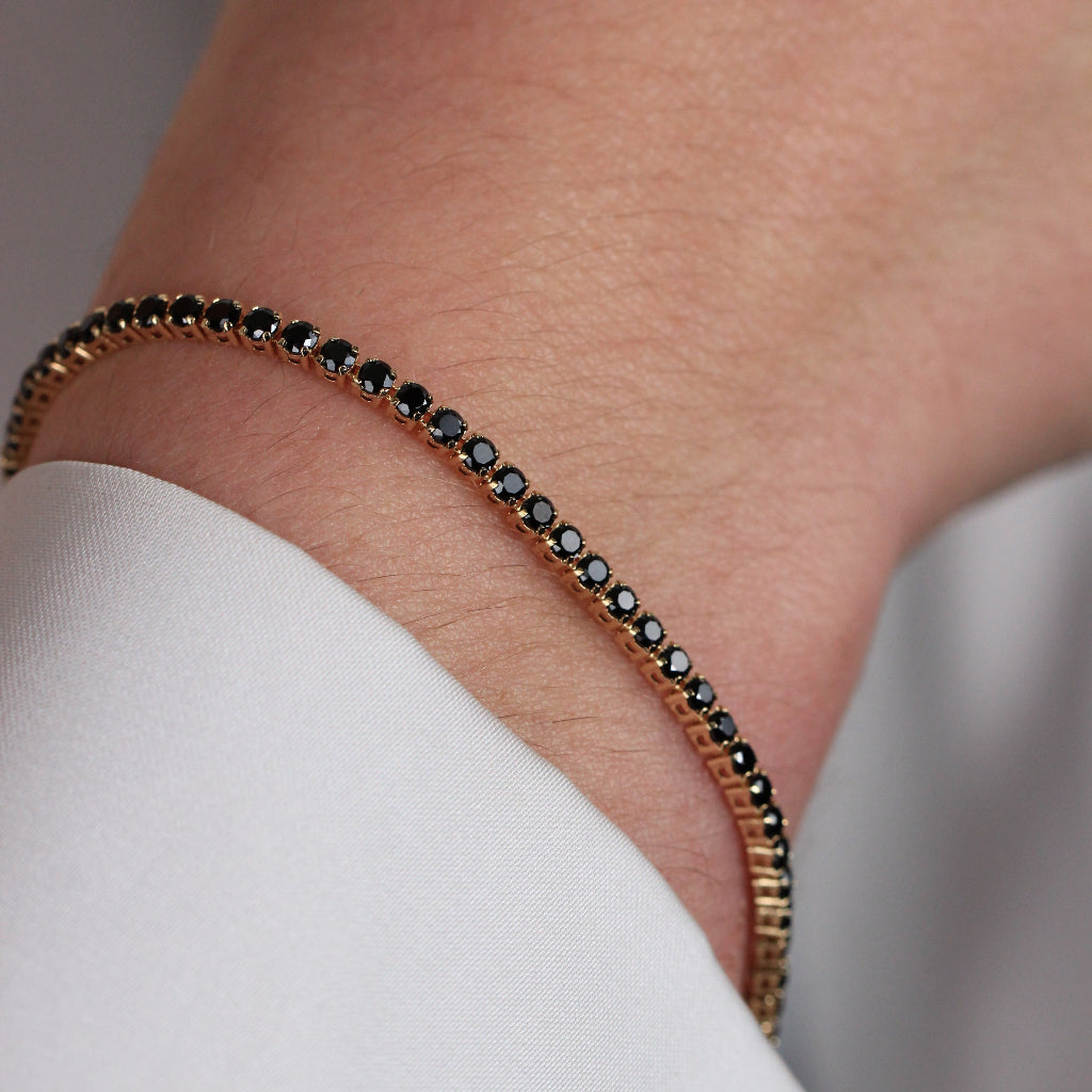 Pulsera realizada en oro amarillo de 18 quilates con circonitas negras.