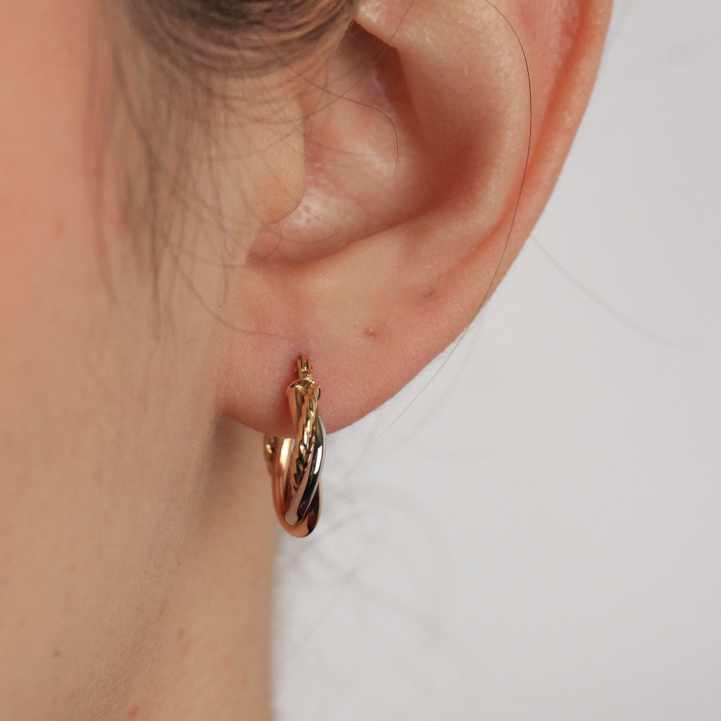 Pendientes de aro tricolor en oro blanco, rosa y amarillo de 18 quilates con tres brazos entrelazados.