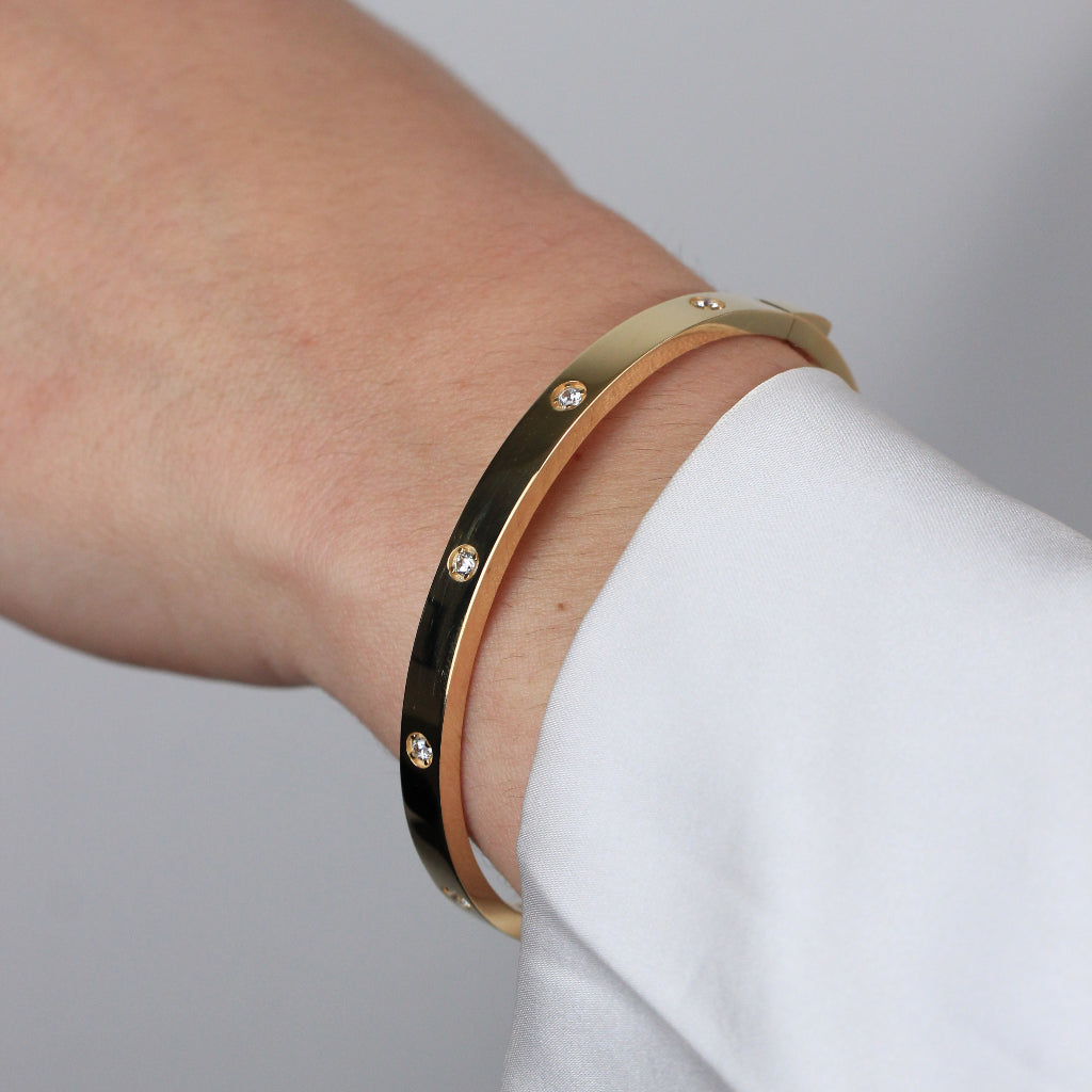 Pulsera rígida esclava realizada en oro amarillo de 18 quilates con circonitas.