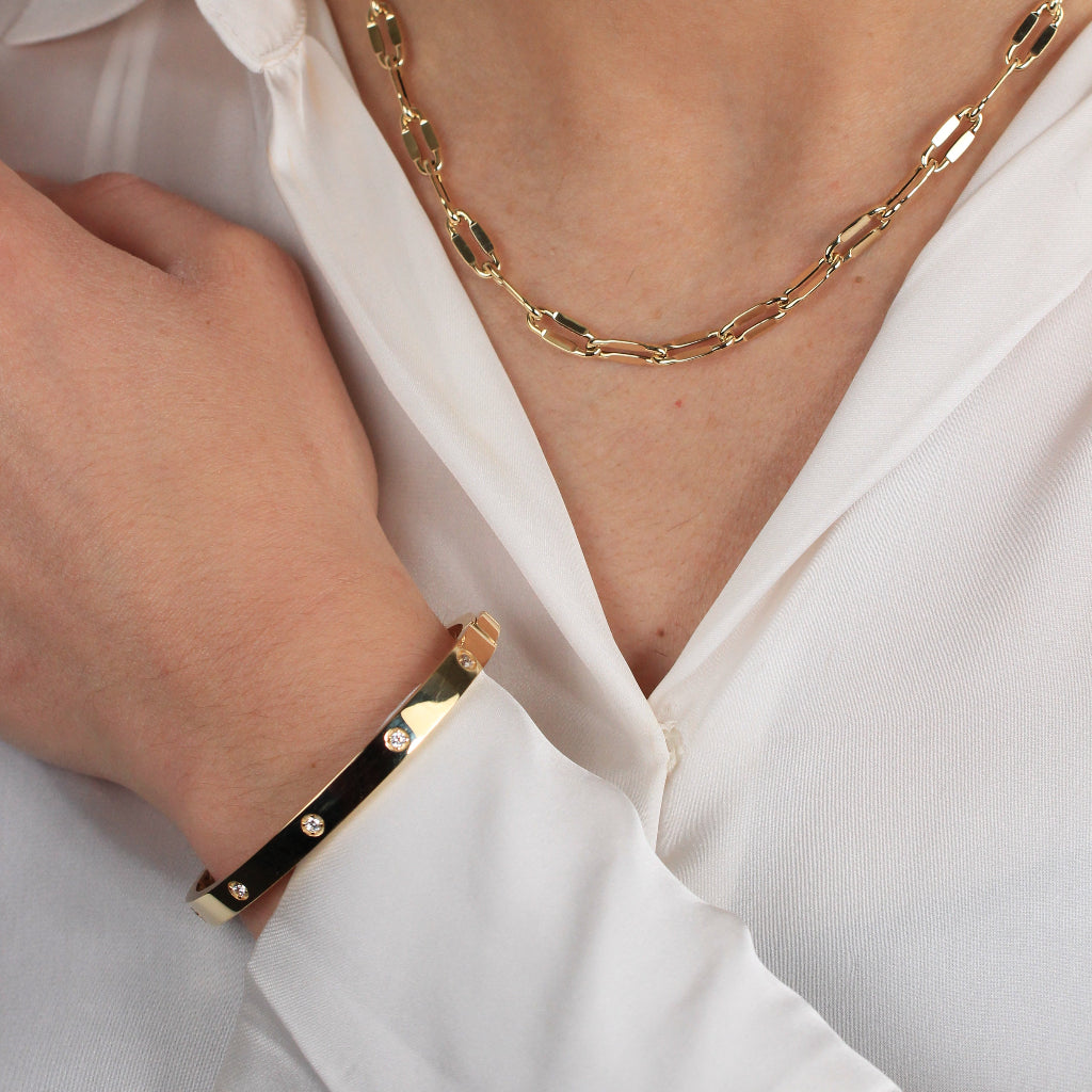 Pulsera rígida esclava realizada en oro amarillo de 18 quilates con circonitas.