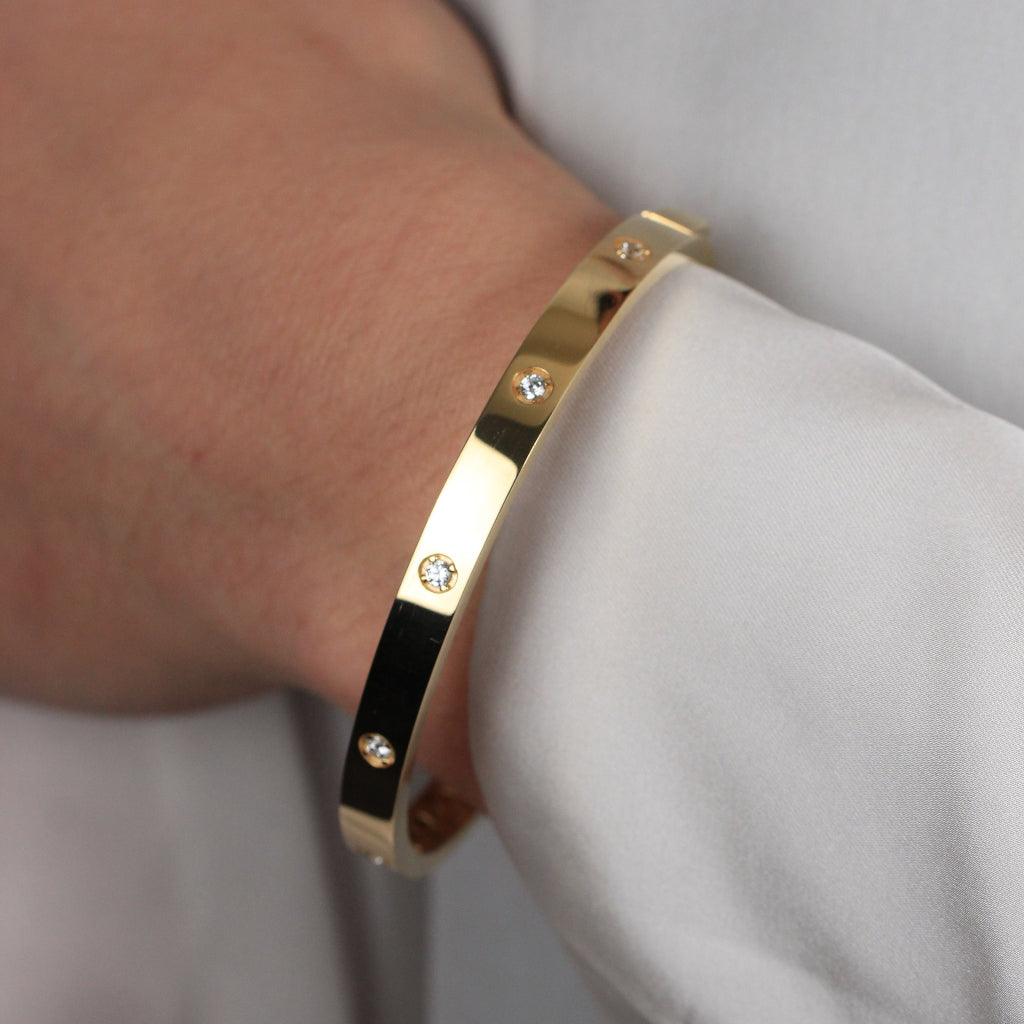 Pulsera rígida esclava realizada en oro amarillo de 18 quilates con circonitas.