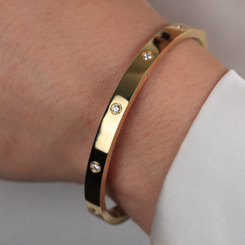 Pulsera rígida esclava realizada en oro amarillo de 18 quilates con circonitas.