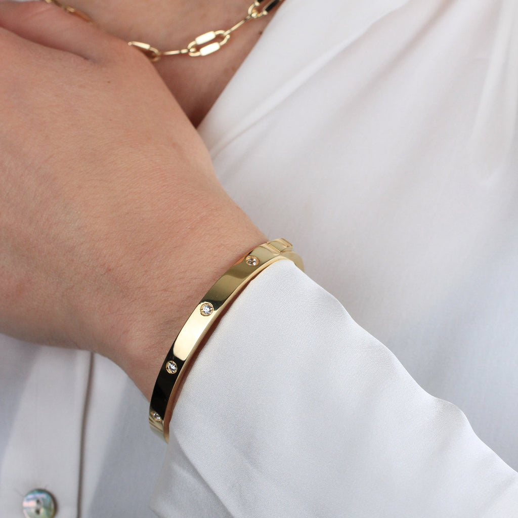 Pulsera rígida esclava realizada en oro amarillo de 18 quilates con circonitas.