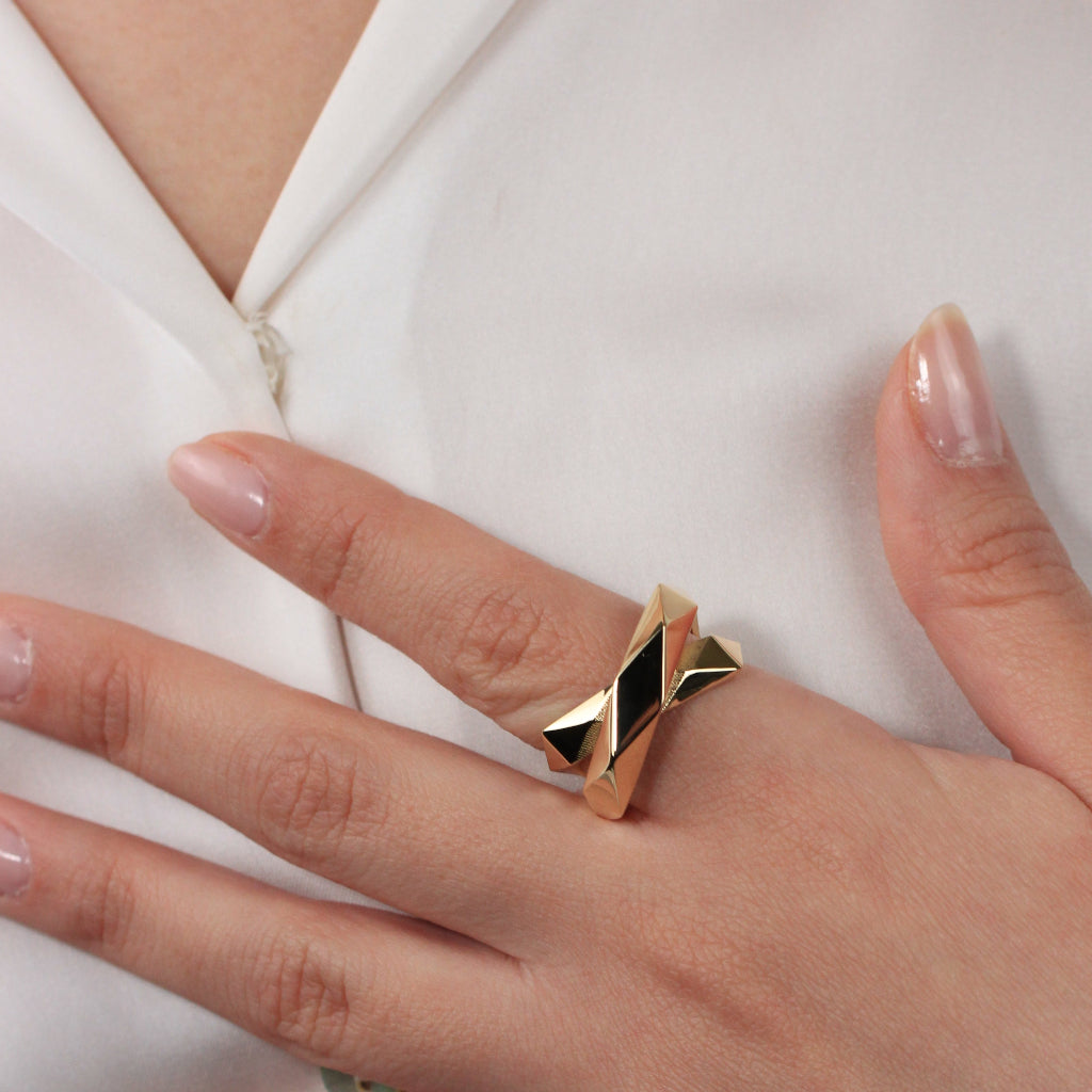 Sortija de oro amarillo de 18kt con dos brazos lisos facetados cruzados.