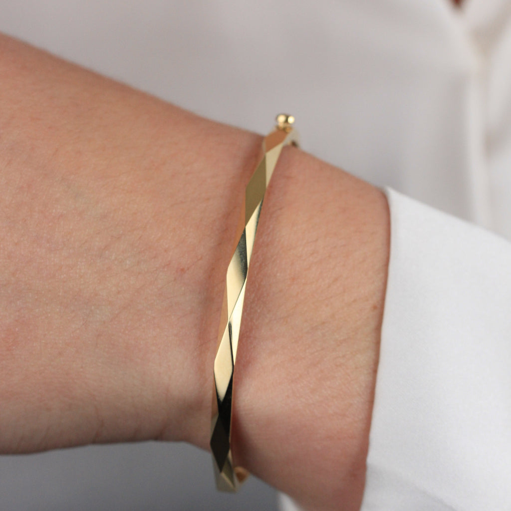 Pulsera rígida esclava realizada en oro amarillo de 18 quilates facetada en rombos.