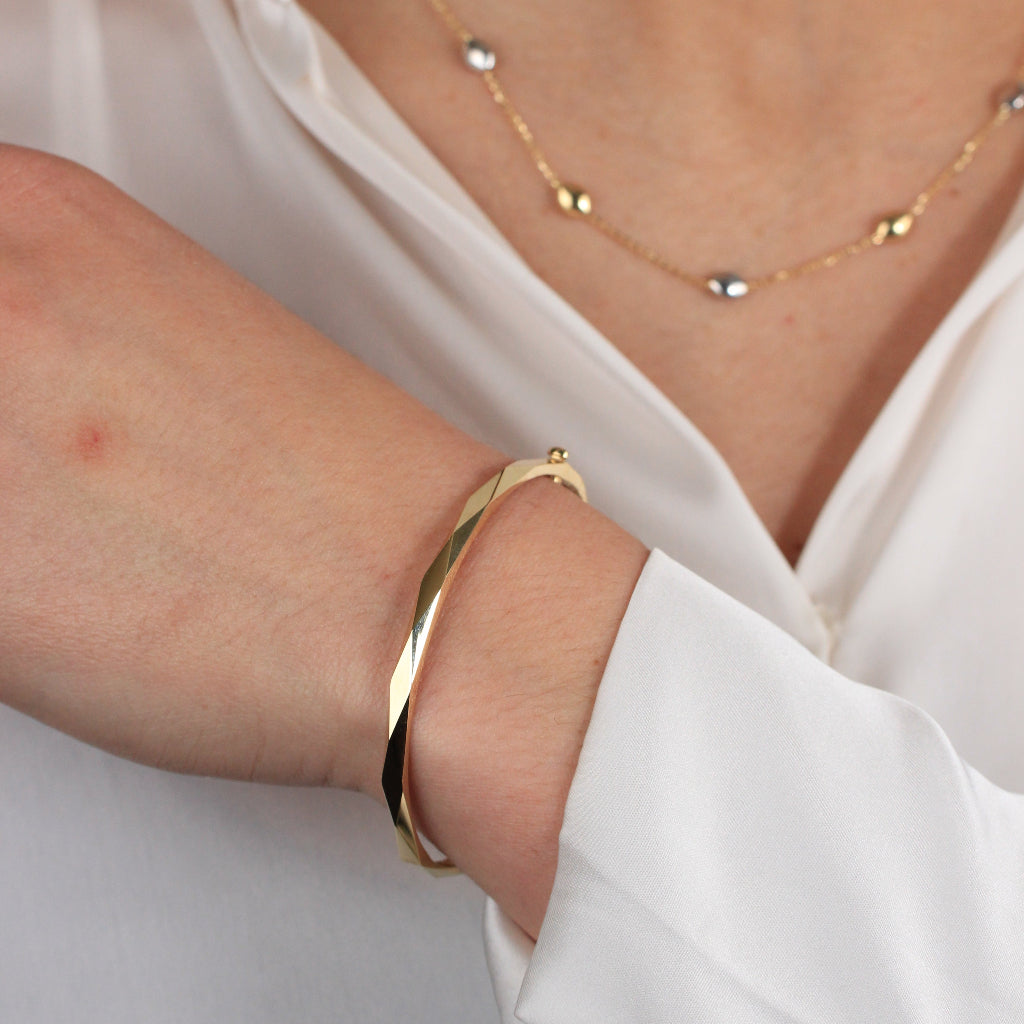 Pulsera rígida esclava realizada en oro amarillo de 18 quilates facetada en rombos.