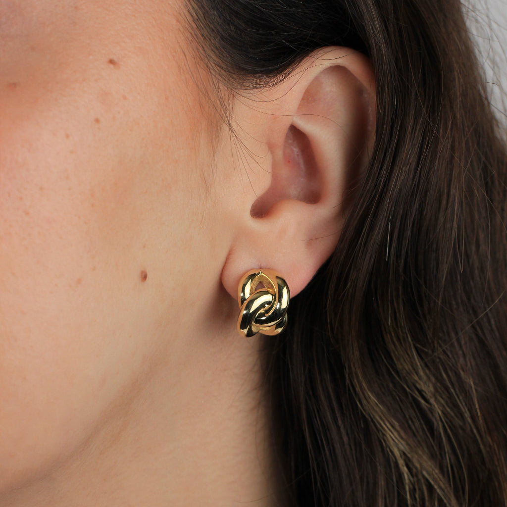 Pendientes en realizados oro amarillo de 18 quilates con dos aros enlazados en forma de ocho. Sistema de cierre omega.