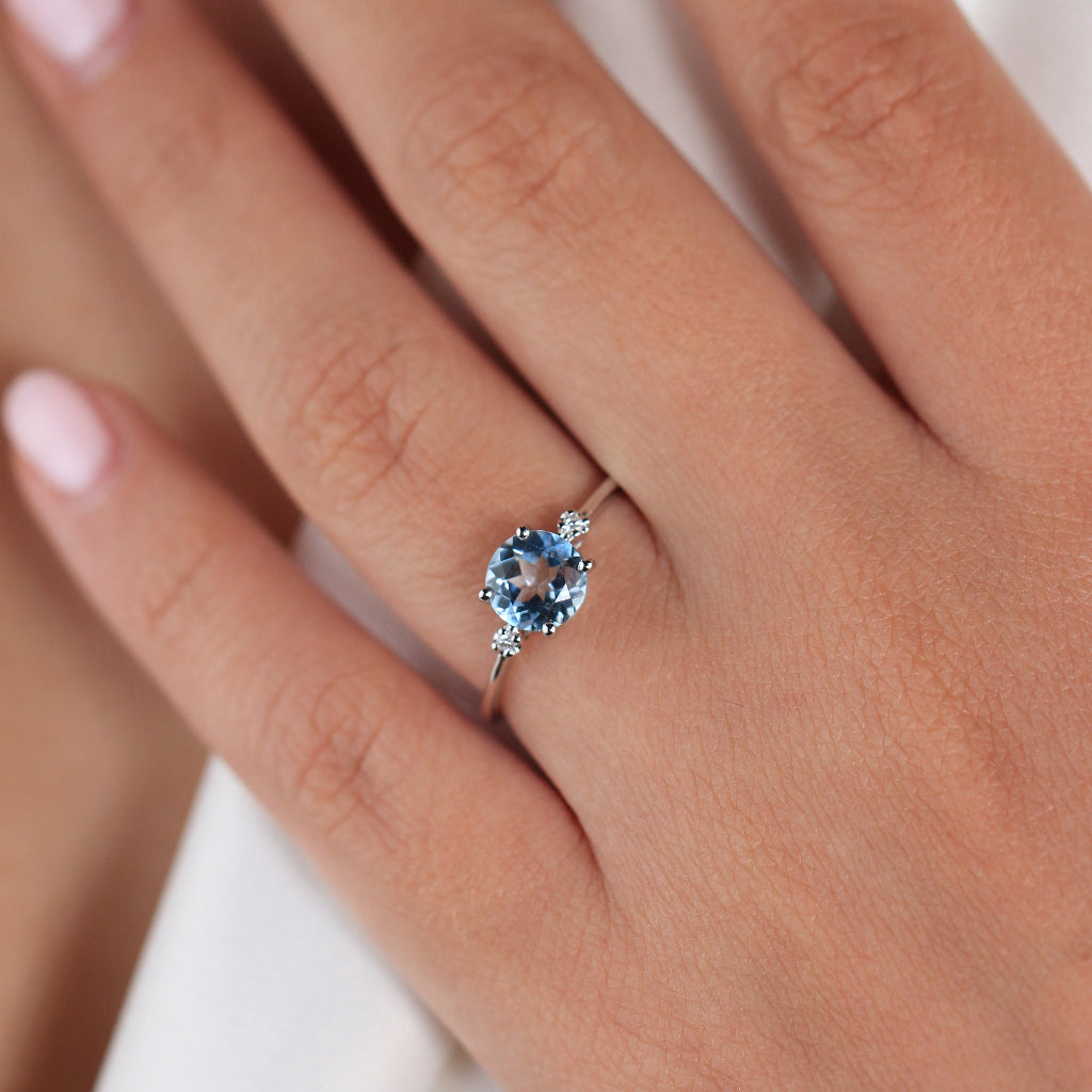 Sortija realizada en oro blanco de 18 quilates con un topacio azul y dos diamantes a los laterales. Joyería Pamplona