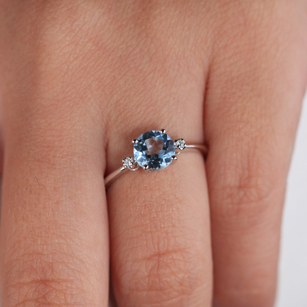 Sortija realizada en oro blanco de 18 quilates con un topacio azul y dos diamantes a los laterales. Joyería Pamplona