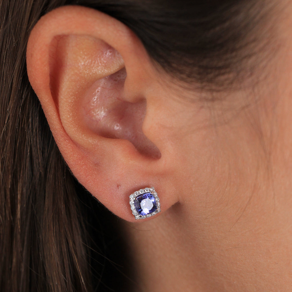 Pendientes de oro blanco de 18k con una tanzanita central y orla de diamantes