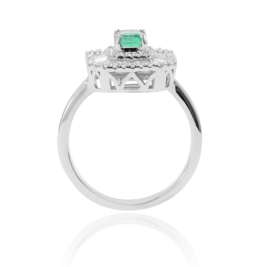 Anillo estilo vintage de oro blanco de 18k con una esmeralda central y orla de diamantes