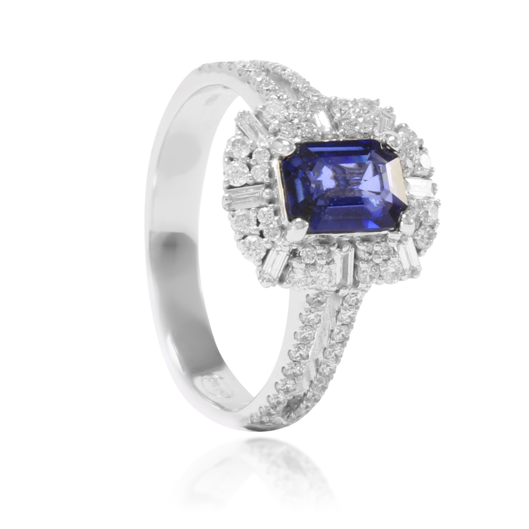 Anillo de oro blanco de 18k con zafiro central, orla de diamantes y diamantes en los laterales