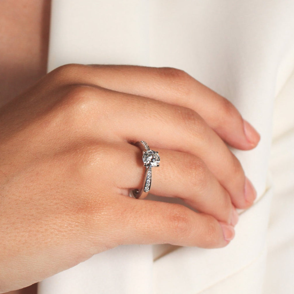 Sortija realizada en platino 960 con un diamante central talla brillante y 12 diamantes en los laterales. Joyería Pamplona