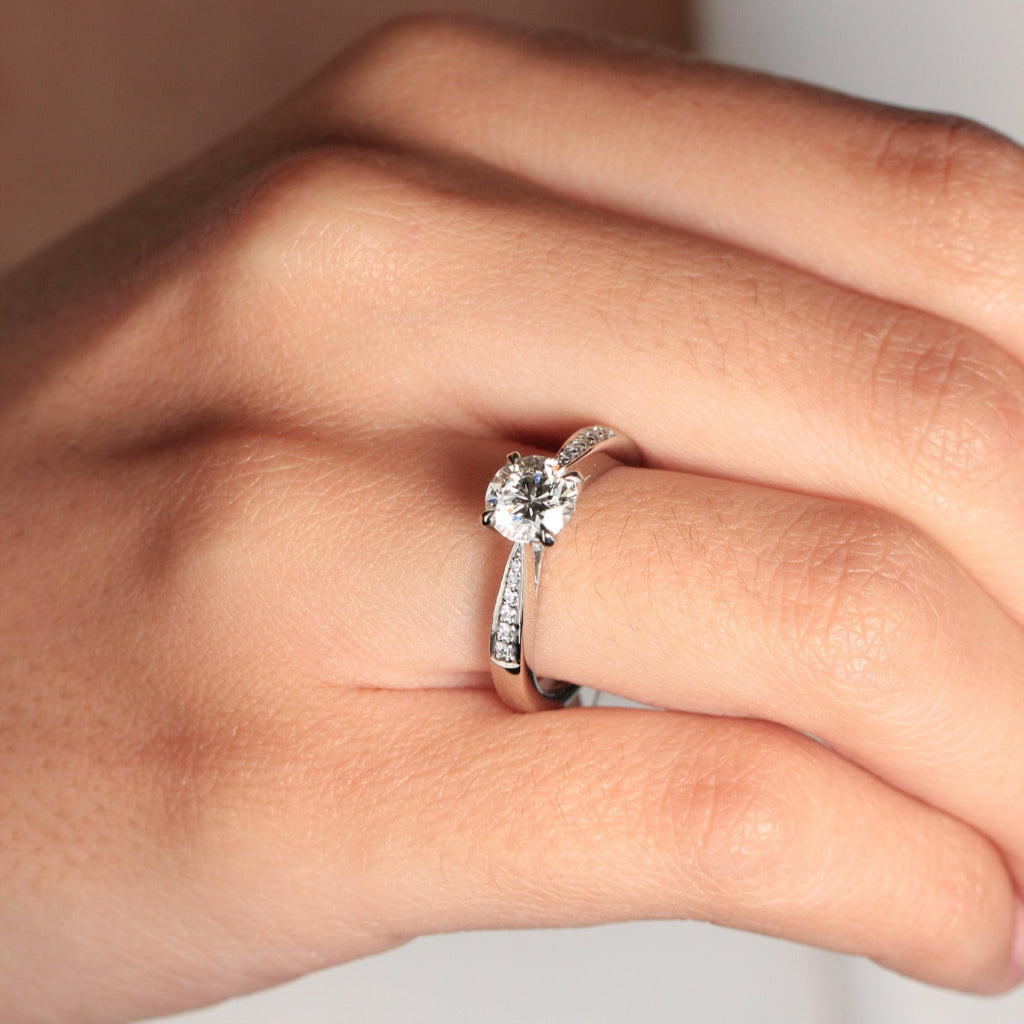 Sortija realizada en platino 960 con un diamante central talla brillante y 12 diamantes en los laterales. Joyería Pamplona