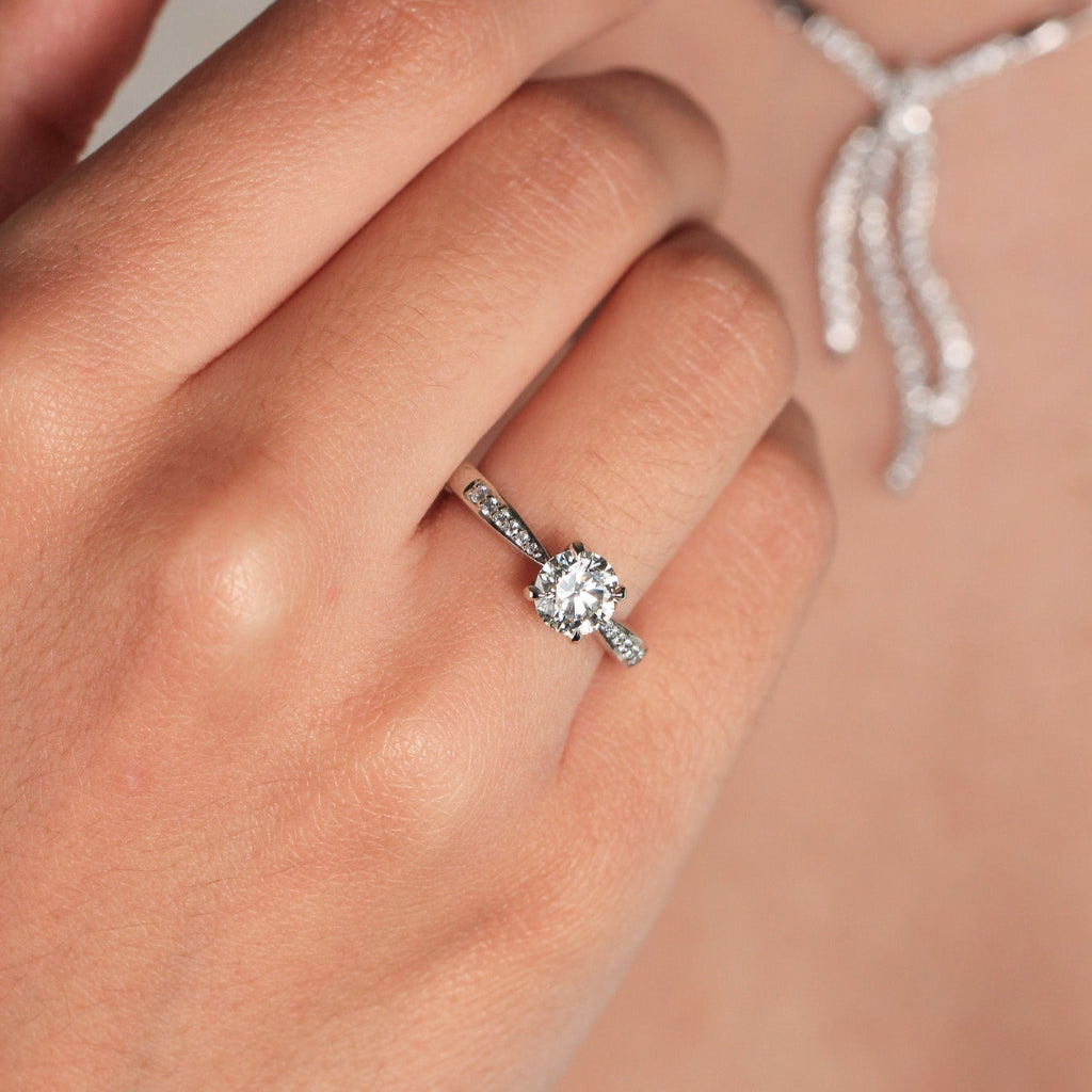 Sortija realizada en platino 960 con un diamante central talla brillante y 12 diamantes en los laterales. Joyería Pamplona