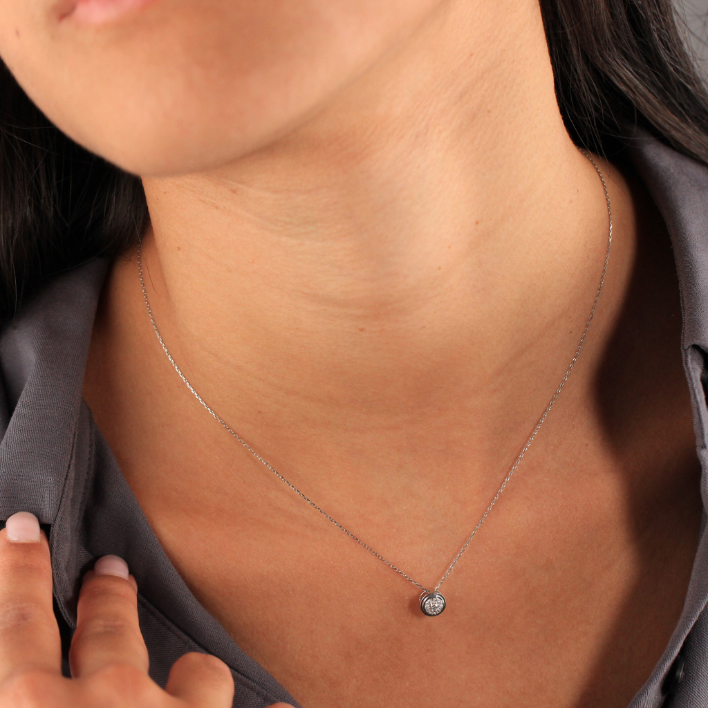 Gargantilla realizada en oro blanco de 18 quilates con un diamante central con diseño de orla circular de diamantes con un peso total de 0,09cts.