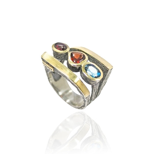 Anillo en plata de ley 925 y oro 9k con granada y topacio azul real.