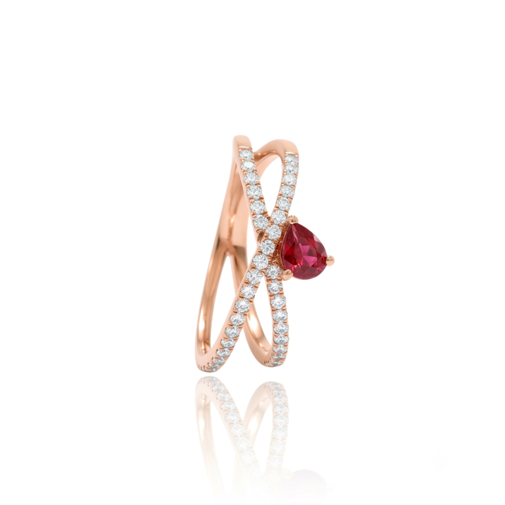 Sortija realizada en oro rosa de 18 K, con un brazo doble cruzado, pavonado con diamantes talla brillante y con un rubí en talla pera engastado en garras.